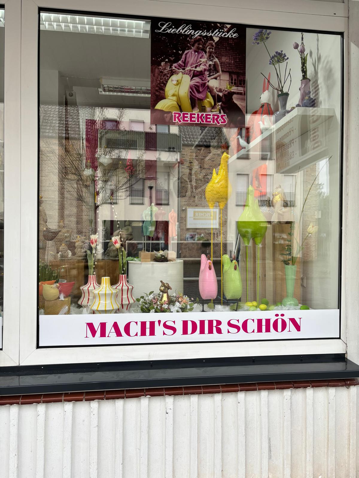 Bunte handgefertigte Vasen mit Frühlingsblumen im Schaufenster